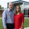 Carlos and Tatiana Ibanez stand in front of Henley Middle School with serious expressions on their faces